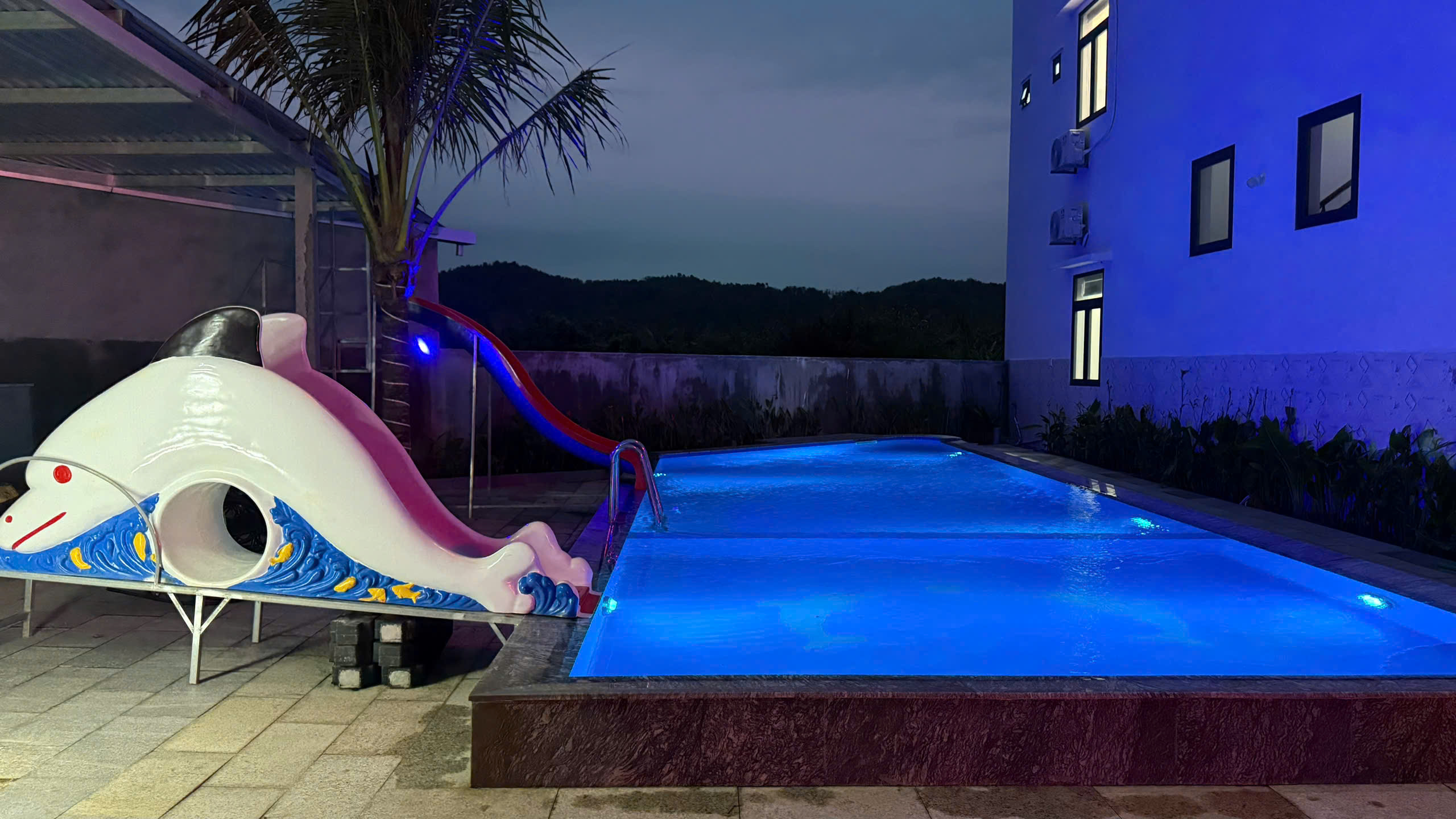 wimming pool glowing with beautiful lights at night at Ganh Da Dia Retreat Hotel